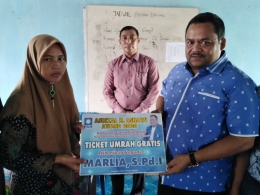 Marlia, S.Pd.I menerima secara simbolis tiket umrah gratis dari Anggota DPR Aceh, Asrizal H Asnawi. Foto: Putra Zulfirman.
