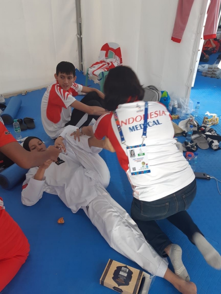 Mbak Kanti, personel tim medis kontingen sedang melakukan fisioterapi kepada salah satu atlet Taekwondo Indonesia.