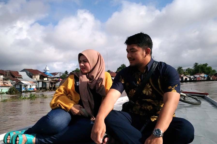 Dua pasangan muda tengah menikmati pemandangan dari atas perahu klotok (sumber: J.Haryadi)