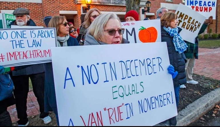 Protesters hold signs near the New Jersey office of Representative Jeff Van Drew on December 12. (Craig Matthews / The Press of Atlantic City via AP)