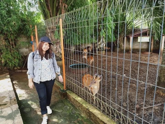 Foto adik bersama rusa dalam kandang. Photo by Ari