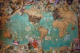 ilustrasi uang-uang yang menguasai dunia. (sumber: https://thriveglobal.com)