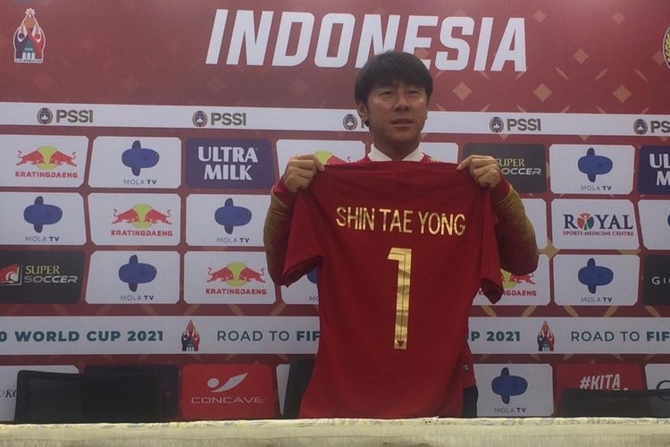 Pelatih baru timnas Indonesia, Shin Tae-yong, mengangkat jersey Merah Putih pada sesi perkenalan di Stadion Pakansari, Kab Bogor, Sabtu (28/12/2019).(BOLASPORT.com/Mochamad Hary Prasetya)