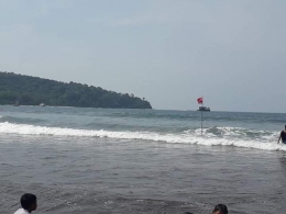 Bendera merah di laut tepi pantai yang merupakan tempat rawan arus deras. Photo by Ari