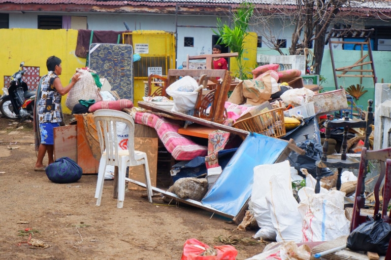 Warga sedang membersihkan sisa-sisa barang yang terkena banjir di kompleks Berlan (dokpri)