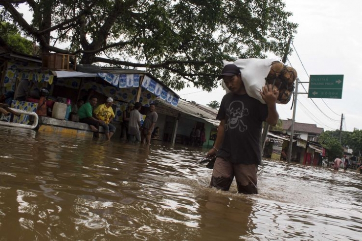 Sejumlah warga mengevakuasi barang berharga yang terendam banjir di Jl. Raya Pondok Gede, Kramat Jati, Jakarta Timur, Rabu (1/1/2020). Luapan air Kali Baru sebabkan wilayah Kramat Jati terendam hingga sebahu orang dewasa.(KOMPAS.com/M ZAENUDDIN)