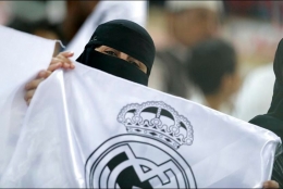 Salah satu suporter perempuan yang membentangkan bendera Real Madrid di laga perdana Piala Super Spanyol 2020, Jeddah (9/1). | Foto: Hassan Ammar/AP Photo