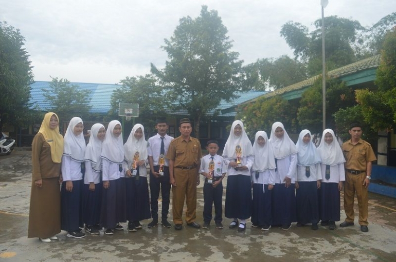 Kepala MTsN 3 HSS H Muliadi, bersama Wakil Kepala Madrasah, foto dengan siswa yang meraih prestasi pada lomba memeriahkan HAB Kemenag Tahun 2020. (foto : akhmad husaini)