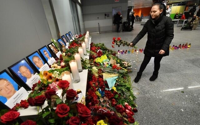 A woman places flowers at a memorial for the victims of the Ukraine International Airlines Boeing 737-800 crash in the Iranian capital Tehran, at the Boryspil airport outside Kiev on January 8, 2020 (Sergei SUPINSKY / AFP)