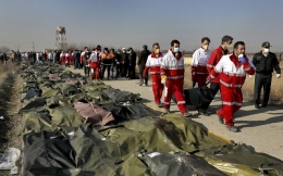 Rescue workers carry the body of a victim of a Ukrainian plane crash in Shahedshahr, southwest of the capital Tehran, Iran, Jan. 8, 2020 (AP Photo/Ebrahim Noroozi)