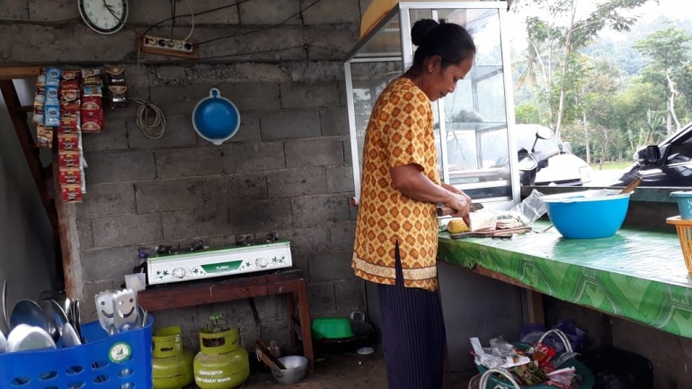 Bu Pariyah, sibuk melayani pembeli sambil memasak. (Dok. Wahyu Sapta).
