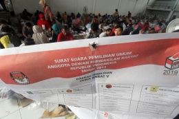 Foto dirilis Kamis (21/3/2019), memperlihatkan pekerja menunjukan surat suara yang rusak saat pelipatan kertas suara Pemilu di Gudang KPU, Cibinong, Bogor, Jawa Barat. (ANTARA FOTO/YULIUS SATRIA WIJAYA)