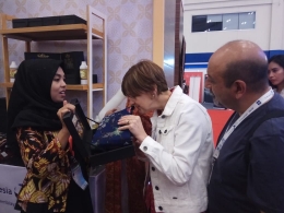 Salah satu pengunjung Trade Expo Indonesia (TEI) asal Inggris sedang mencium aromaterapi batik tulis Al-Warits. Per bulannya Al-Warits mengekspor pasar AS sebanyak 5.000 lembar kain batik. (Foto: Dok. Yakob Arfin)