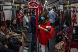 Para penumpang kereta di Hongkong memakai masker demi mengantisipasi penularan virus Corona tipe baru. Sumber: Dale De La Rey/AFP/Getty Images via Vox