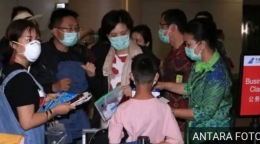 Turis China yang akan kembali ke negaranya di bandara Bali sebelum jalur penerbangan ditutup (Antara Foto, dimuat bbc.com)