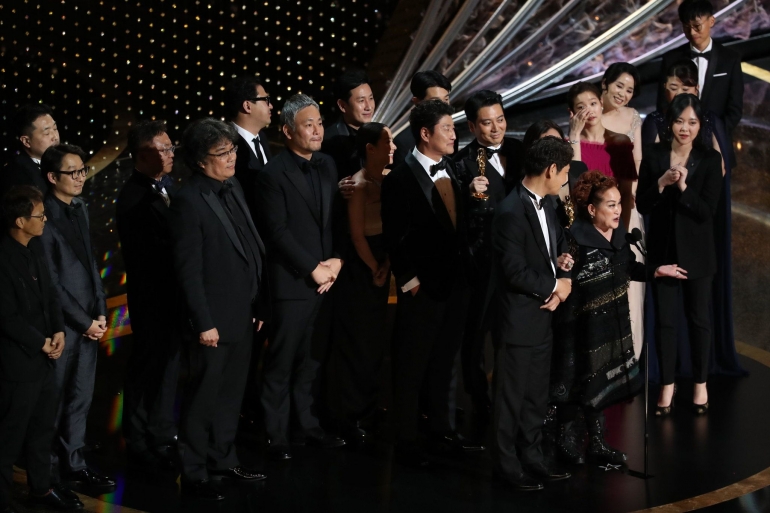 Seluruh pemeran dan sutradara "Parasite" berdiri di atas panggung untuk menerima penghargaan (sumber: nytimes.com)