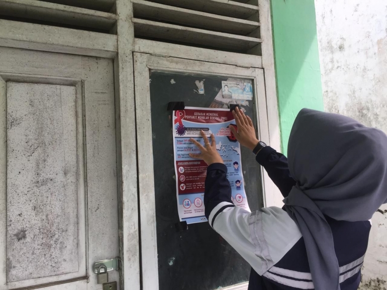 Pemasangan leafet PMS HIV/AIDS oleh Mahasiswa KKN Undip 2020. (Dokumen pribadi).