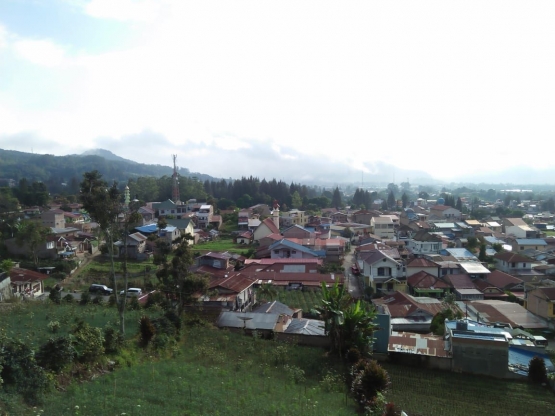 Pemandangan ke arah lembah di bawah Bukit Gundaling, tampak kepadatan pemukiman penduduk kini di Kota Berastagi (dokpri)