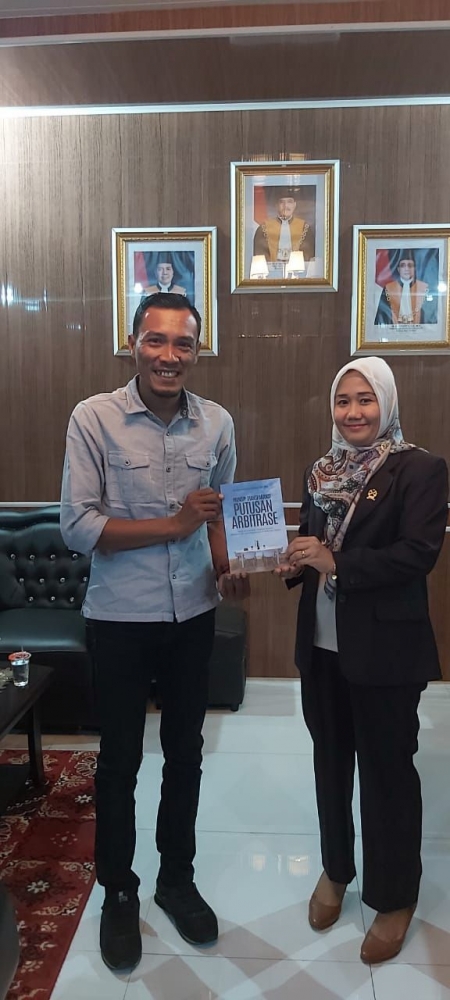 Ketua PN Langsa, Nurnaningsih Amriani menyerahkan buku karangannya kepada Ketua PWI Kota Langsa, Putra Zulfirman. (Foto/El Kurniawan)