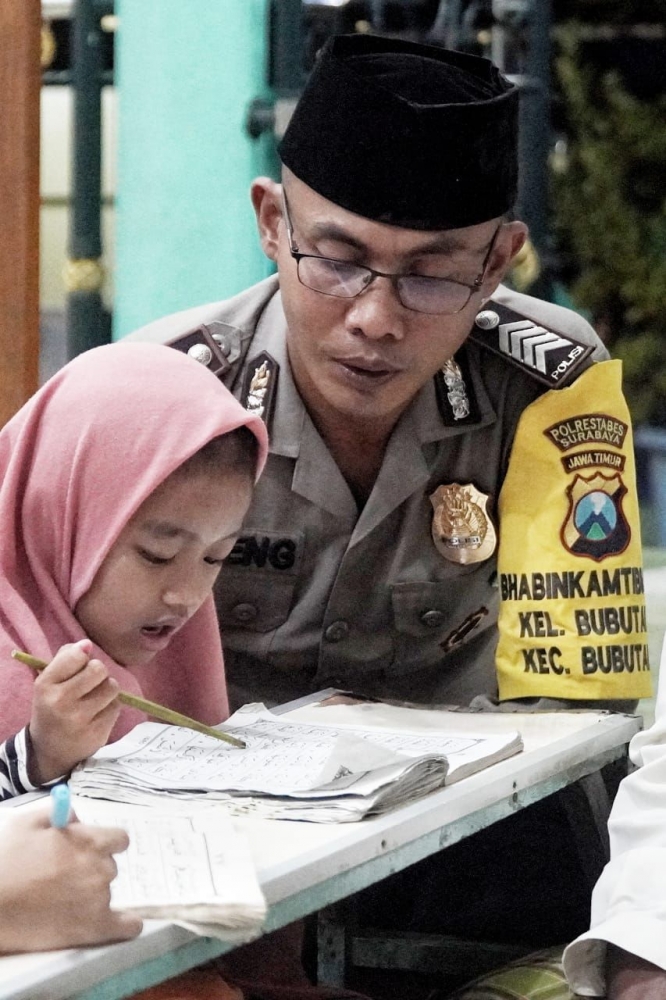 Bhabinkamtibmas Polsek Bubutan, Polrestabes Surabaya ( Bripka Sugeng ) saat Membantu menggajar mengaji 