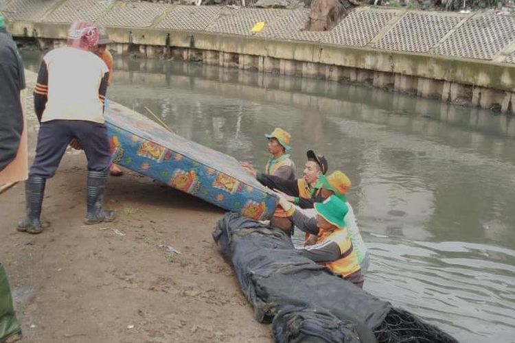 Tim UPK Badan Kali Jakarta Barat mengangkat sampah kasur di Kali Grogol, Jakarta Barat (dokumentasi Tim UPK Badan Kali Jakbar melalui kompas.com)