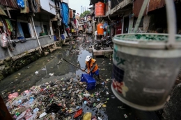 Seorang petugas membersihkan sampah di bantaran kali di Jalan Jati Bunder, Kelurahan Kebon Melati, Kecamatan Tanah Abang, Jakarta Pusat, Selasa (5/9/2017). (KOMPAS.com/GARRY LOTULUNG)