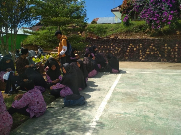 Suasana belajar di luar kelas menggunakan smartphone. Photo By. Hj. Nelfitra, S.Pd