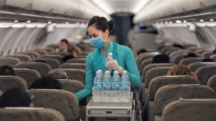 Pramugari Vietnam Airlines menggunakan masker saat layani penumpang (TribunNews/Business Traveller)