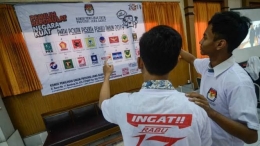 Dua siswa Sekolah Menangah Atas memperhatikan gambar partai politik peserta pemilu 2019 di Komisi Pemilihan Umum (KPU) Jawa Barat, Bandung. Foto: ANTARA