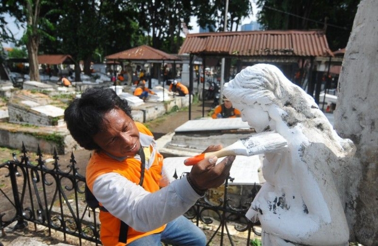 Seorang pekerja mengecat patung | ngopibareng.id
