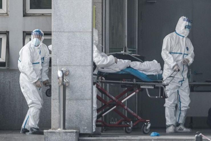 Petugas medis membawa seorang pasien yang diduga terinfeksi virus misterius mirip SARS, ke rumah sakit Jinyintan, di Kota Wuhan, China, Sabtu (18/1/2020). Virus misterius mirip pneumonia telah menjangkiti puluhan orang dan menelan korban jiwa kedua di China, menurut pemerintah setempat.(AFP/STR/CHINA OUT via KOMPAS.com)