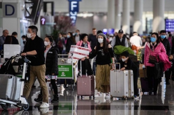 Para penumpang pesawat terbang mengenakan masker wajah untuk antisipasi wabah Virus Corona. (Foto: AFP)