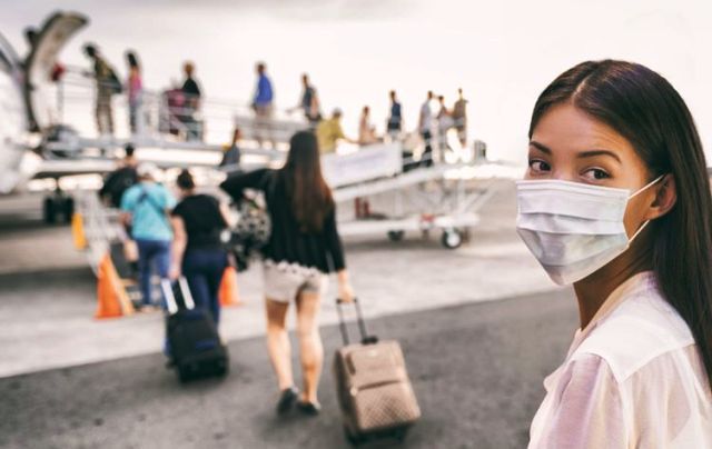 Penumpang Pesawat Menggunakan Masker (Foto: Kompas.com)