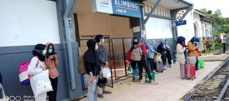 Penumpang menanti KA datang di Stasiun Blimbing dengan rerata orang mengenakan masker