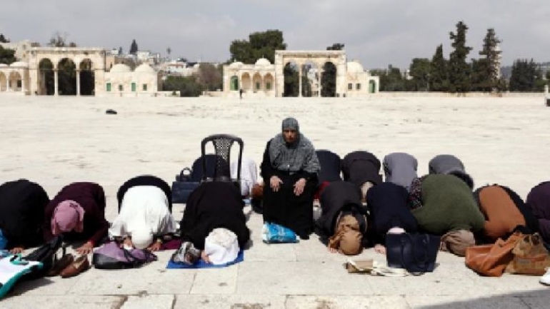 Jamaah perempuan, 15 Maret 2020, shalat di ruang terbuka Kompleks Al-Aqsa karena ruang utama masjid ditutup sementara. (Foto: Ammar Awad/Reuters)