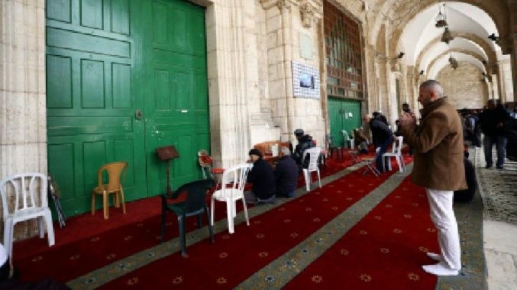 Masjid Al-Aqsa ditutup sementara, 15 Maret 2020, jamaah shalat di luar ruangan utama. (Foto: Ammar Awad/Reuters)