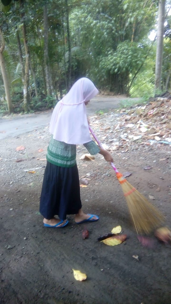 Anak sedang menyapu halaman/dok.pri