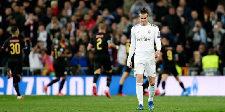 Pemain Real Madrid, Gareth Bale, tertunduk di tengah selebrasi skuad Manchester City. AP Photo | Bola.net 