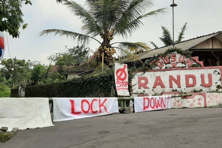 Akses jalan menuju Dusun Baratan, Desa Candibinangun, Kecamatan Pakem ditutup sementara dan ditulisi Lock Down (Foto: KOMPAS.COM/YUSTINUS WIJAYA KUSUMA)