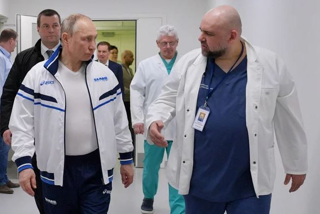 Presiden Rusia Vladimir Putin dan kepala rumah sakit Denis Protsenko berjalan ke rumah sakit untuk menengok pasien virus corona di Kommunarka, di luar Moskow, Rusia. (File / AP / Foto Kremlin / Alexei Druzhinin / Sputnik)