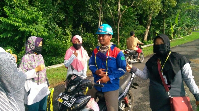 sumber gambar: Dokpri (Anggota Bumdes Renajaya sedang memberi masker ke pekerja yang tetap bekerja di masa pandemi covid-19)
