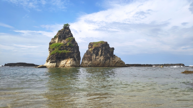 Sepasang batu karang raksasa jadi ikon Pantai Tanjung Layar.