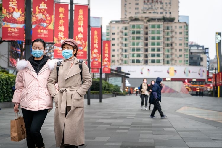 Ilustrasi warga China mengenakan masker di tengah wabah virus corona (Covid-19). (sumber: SHUTTERSTOCK/IHOR SULYATYTSKYY via kompas.com)