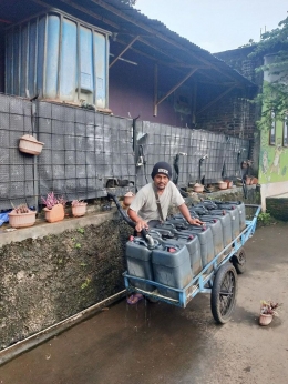 Mang Asep mengisi air di pusat penampungan untuk dijajakan berkeliling sejumlah perumahan. (foto: dok. pribadi)