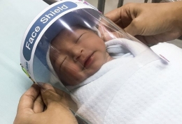 Face shield pada bayi | REUTERS / Athit Perawongmetha, Republika.co.id