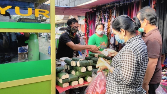 Penjual dan pembeli tempe kenakan masker di Pasar Rakyat Pamulang, Kota Tangsel, Minggu pagi (19/04/2020). (Foto: Gapey Sandy)