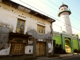 Masjid Menara Layur diapit bangunan kuno yang tak terawat. Tampak menara masjid yang aslinya merupakan sebuah mercusuar. Dokumen Pribadi