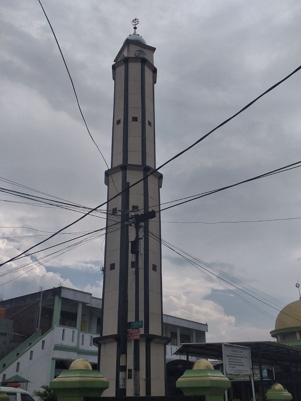 Kabel listrik dan telpon tumpang tindih menghiasi menara masjid.