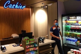 Di tengah meningkatnya kasus pandemi corona di Singapura, seorang karyawan NUS CO-OP terlihat memakai masker, Kamis siang (26/3/2020). NUS CO-OP adalah koperasi dan toko buku yang berlokasi di National University of Singapore, Singapura Barat.(ERICSSEN/KOMPAS.com) 
