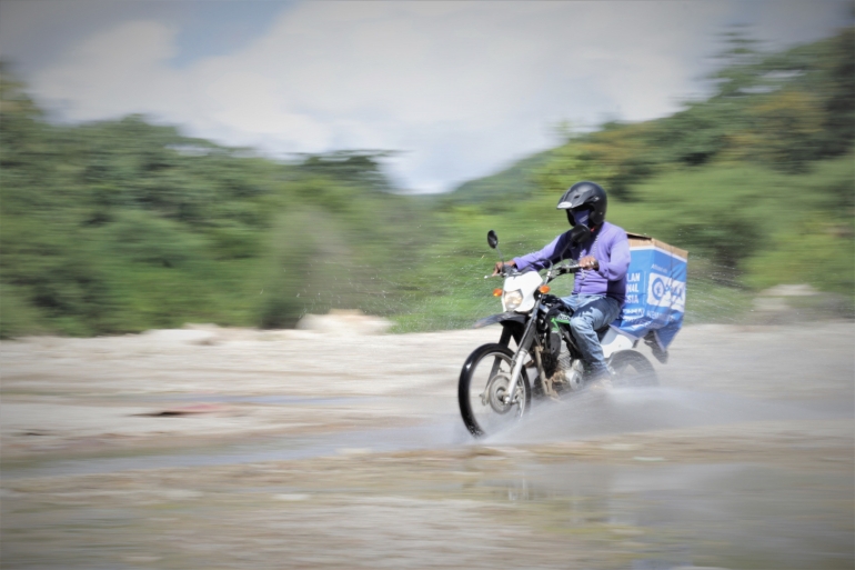 Seorang staf mitra Plan Indonesia yang mengendarai sepeda motor saat distribusi Hygiene Kit. Foto: Agus Haru/Plan Indonesia 